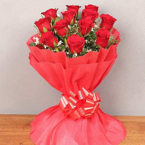 Bunch of 12 red roses in red paper packing