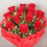 Bunch of 12 red roses in red paper packing